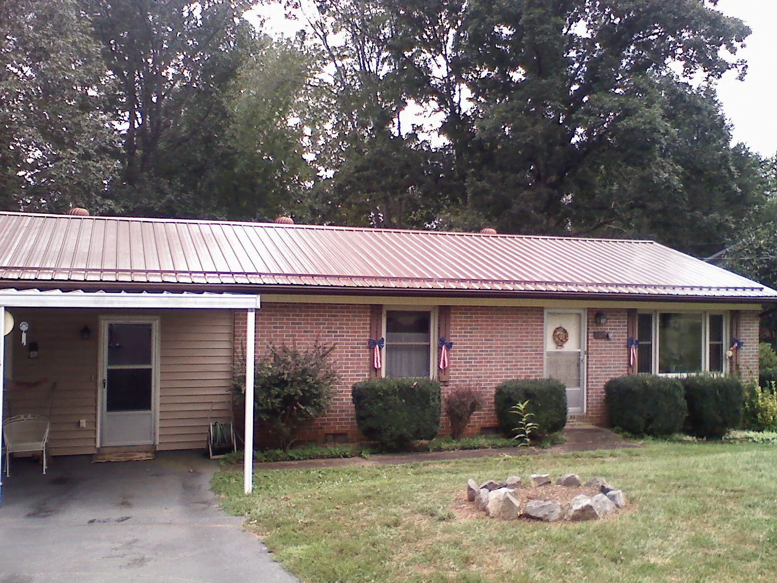 Bronze metal roof and carport on a brick ranch home — Roof Repair work by our crew in Freedom